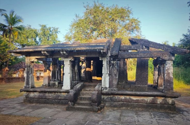 An open stone mandapa temple with a flight of steps flanked by carved balustrades at Barkur