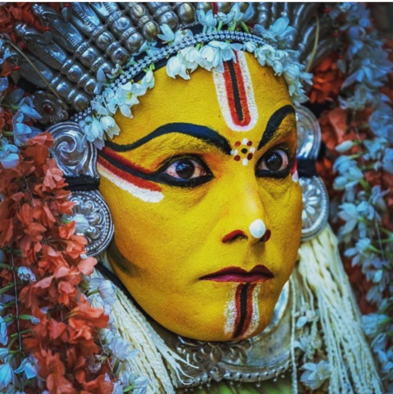 Close-up of the painted face and ornament of a Daiva performer