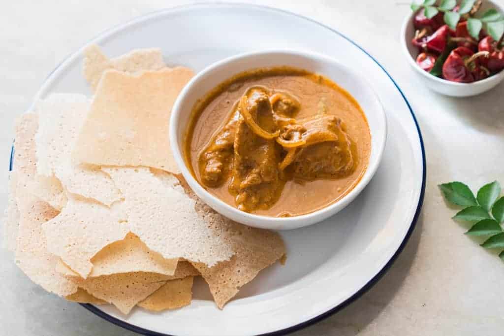 Kori Rotti, crisp rice wafers served with spicy chicken curry