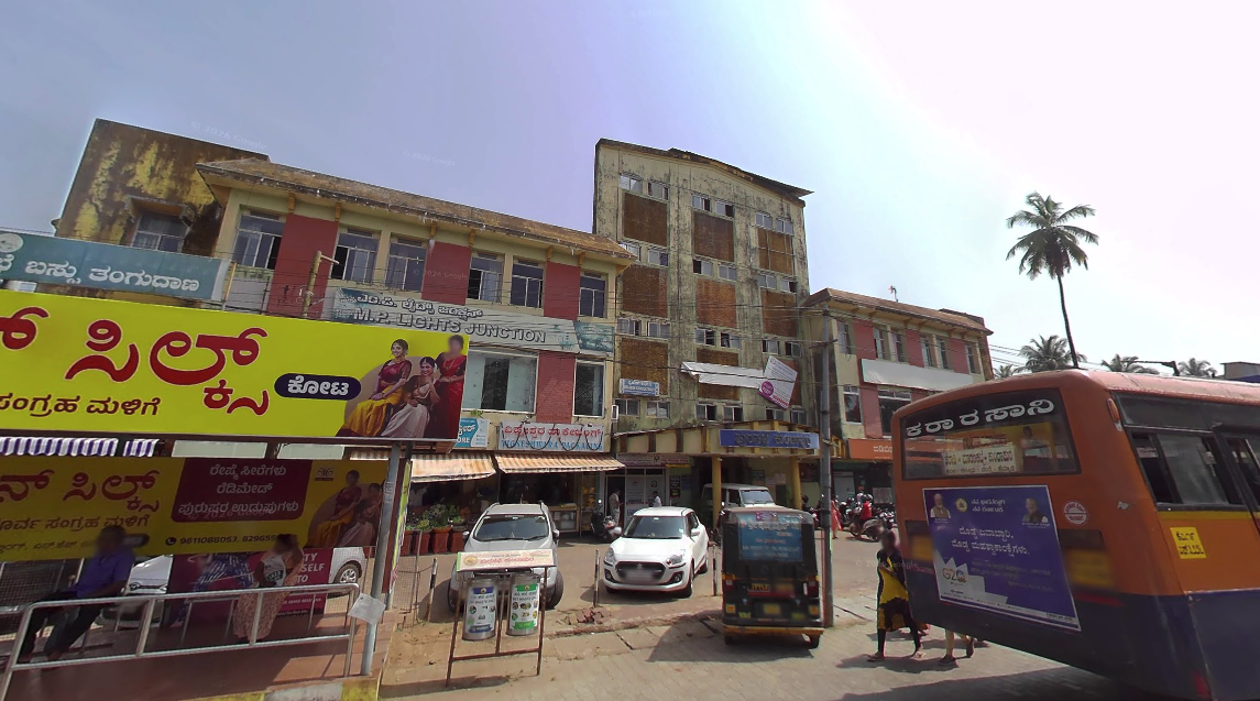 A busy junction in Kundapura town with shops, an autorickshaw and a KSRTC bus — the civic and commercial centre of the taluk headquarters