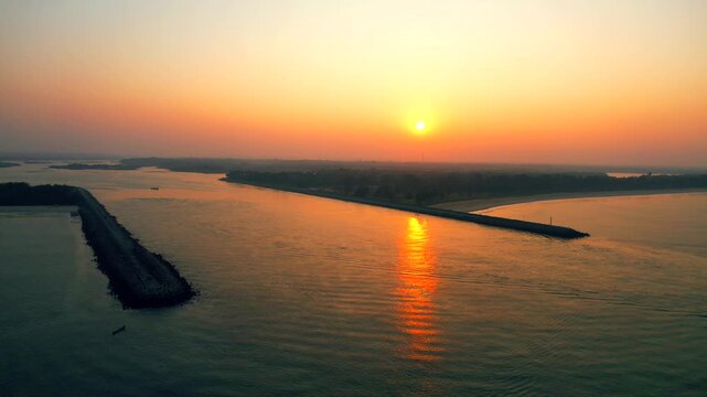 Sunset over the river mouth and breakwaters at Kundapura