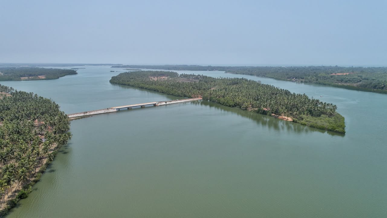 Aerial view of the Panchagangavalli estuary with palm-covered river islands and a low causeway near Kundapura