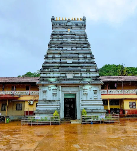 The newly built stone gopura of Kamalashile temple before a rain-soaked courtyard