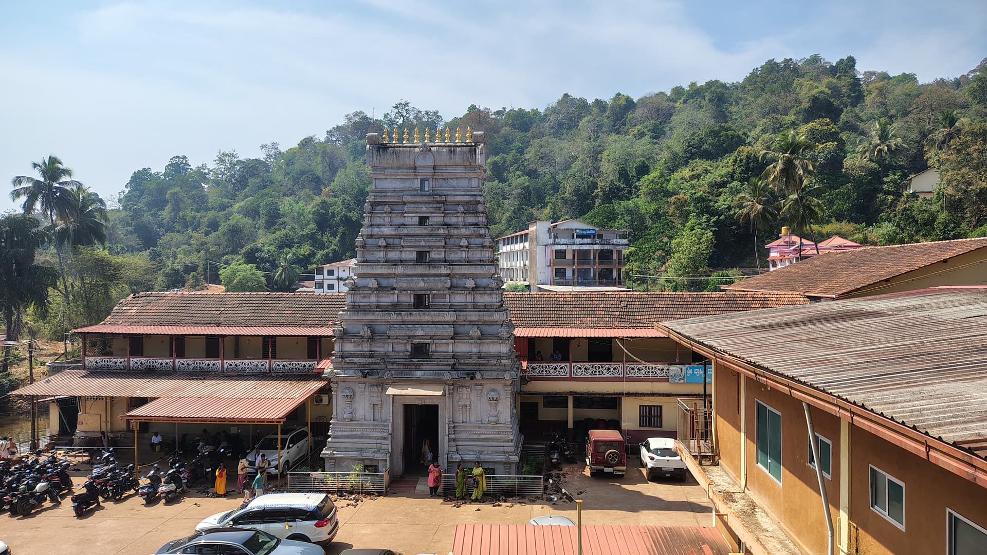 The stone gopura of the Kamalashile Brahmi Durgaparameshwari temple rising before the forested hills of the Western Ghats