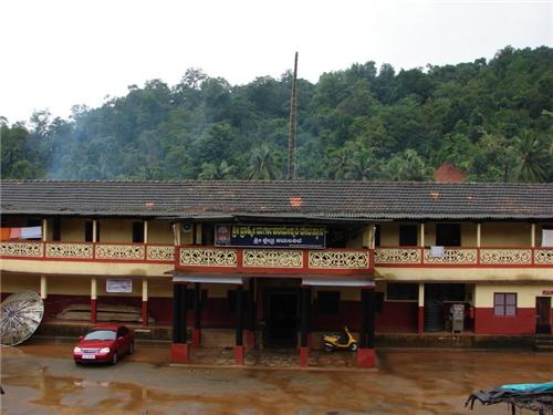 The older tile-roofed temple building at Kamalashile with painted balconies