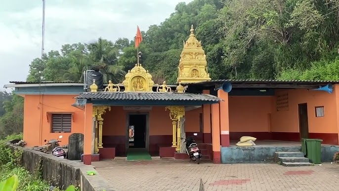 The Someshwara Shiva temple at Byndoor with a golden gopura against a forested hillside